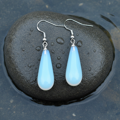 Licht blauwe edelstenen oorbellen met opaal en sterling zilver (925) liggend op steen in water | Sea Opal Long Drop
