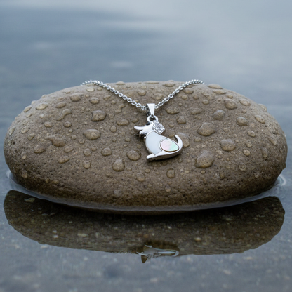 Parelmoeren ketting met hanger met wit en grijs parelmoer in de vorm van een hond met stras steentjes en zilver edelstaal liggend op steen | Shell Dog