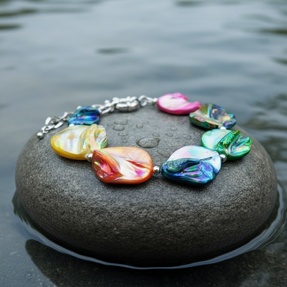 Zijaanzicht kleurrijke parelmoer schelp armband op natte grijze steen
