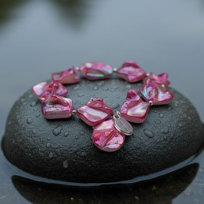 Pink gekleurd parelmoeren schelpen armband liggend op steen in water close up | Shell AB Pink