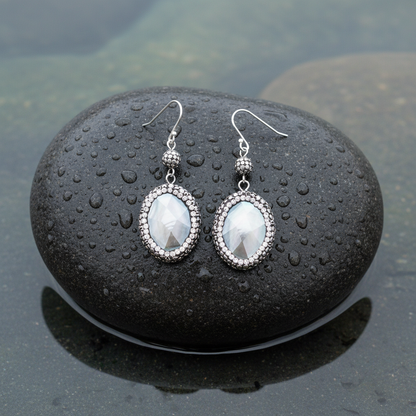 Bovenaanzicht oorbellen op grote donkere steen