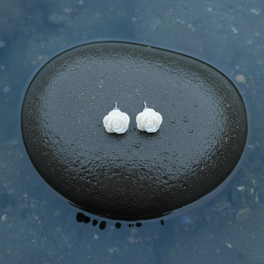 Witte parelmoeren oorknopjes in bloem vorm met sterling zilver 925 liggend op steen in water | White Shell Flower 7,5 mm