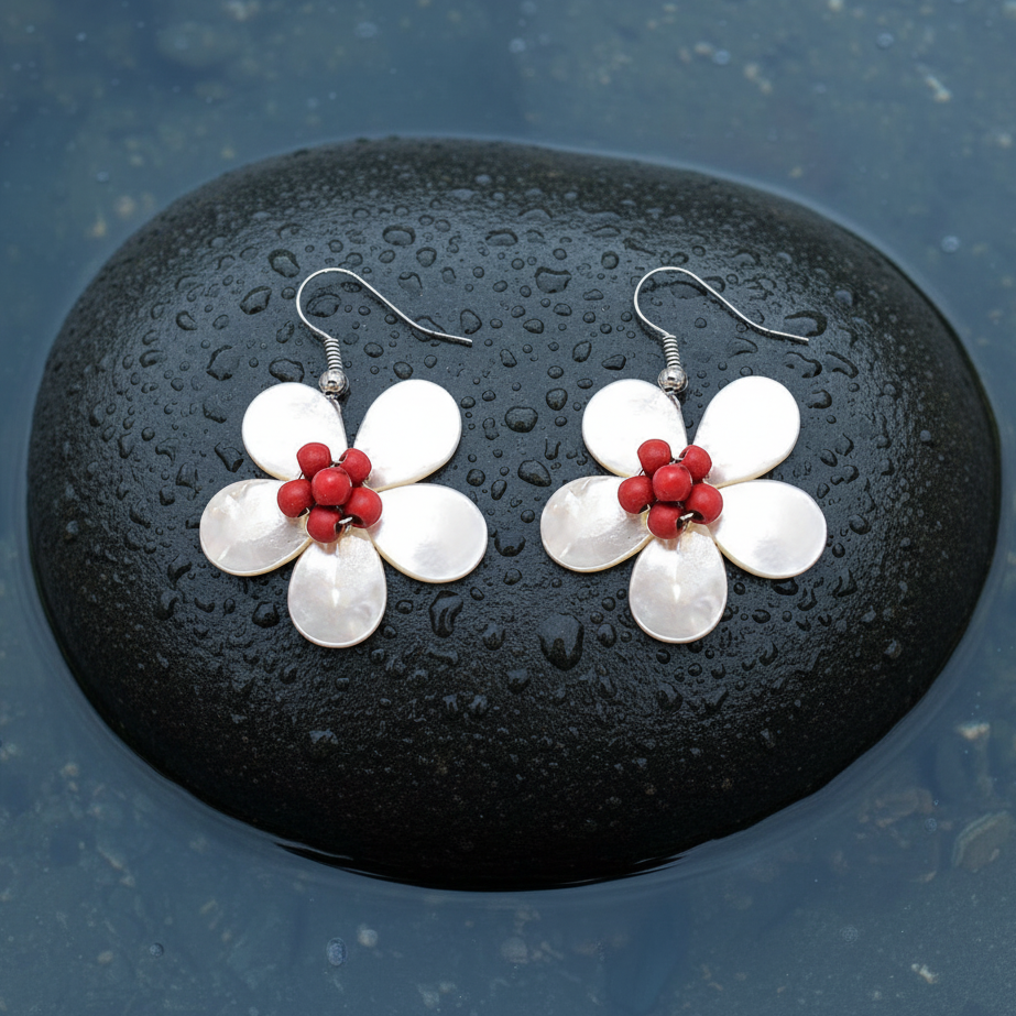 Parelmoeren oorbellen met wit parelmoer in de vorm van een bloem en zilver edelstaal liggend op steen in water | White Shell Flower Red Stone