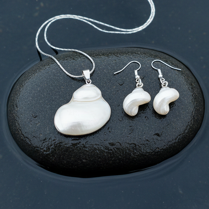 Witte parelmoeren schelpen set bestaande uit een schelpen ketting en schelpen oorbellen met zilver edelstaal liggend op steen in water | set Pearl White Turbo Shell