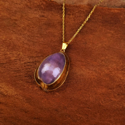 Paarse schelpenketting met goud edelstalen ketting liggend op hout | Shell Cowrie Purple