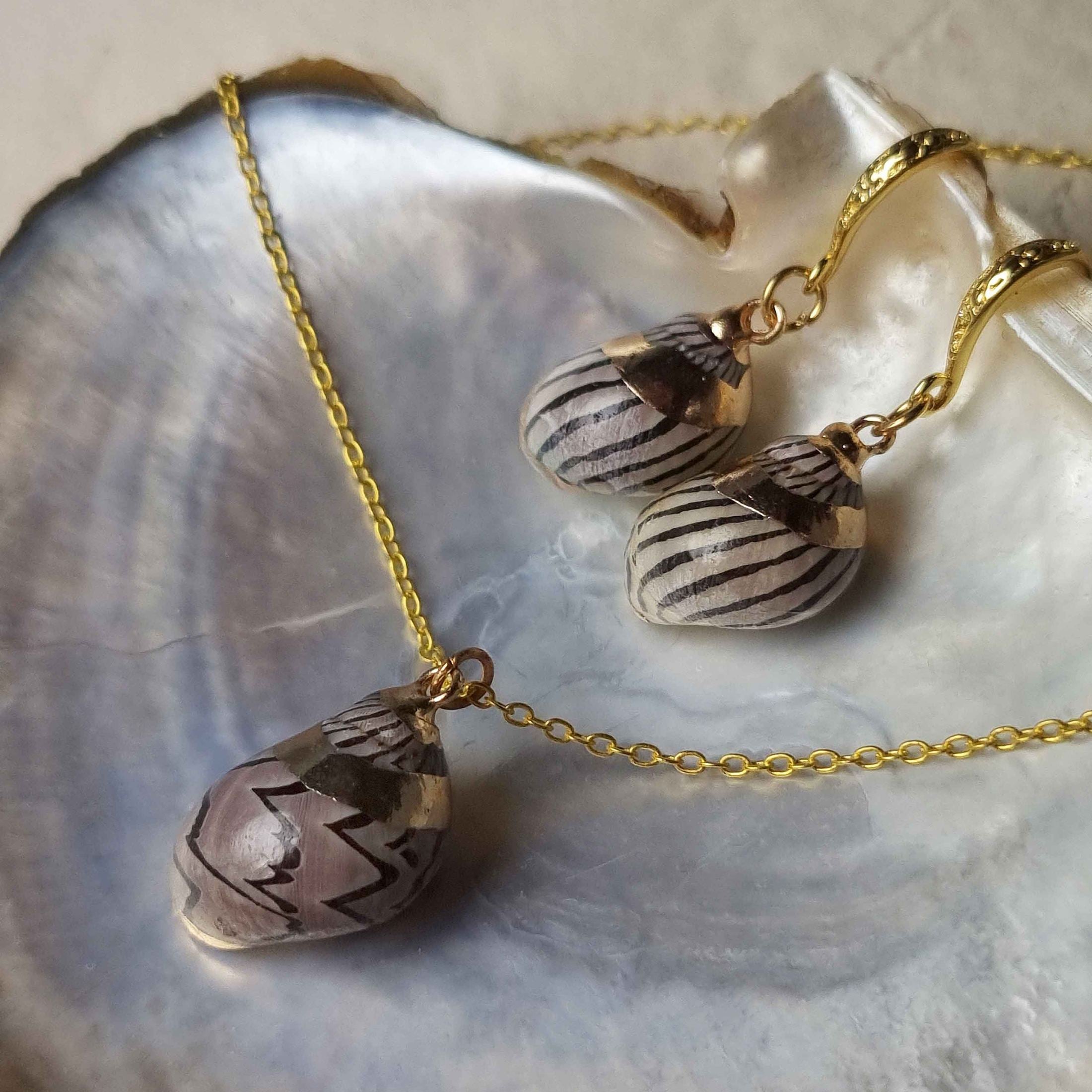 Schelpen sieraden set bestaande uit een schelpen ketting en schelpen oorbellen met bruine schelp liggend in schelp | set Gold Spiral Shell