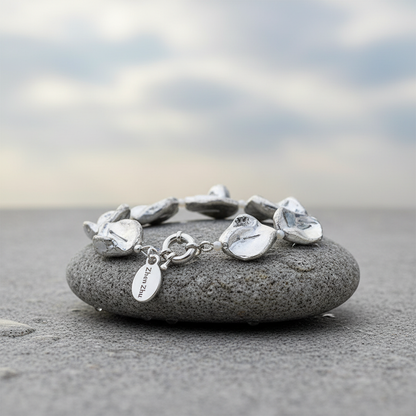 Zilver kleurige parelmoer schelpen armband liggend op steen met slotje voor | Shell Silver