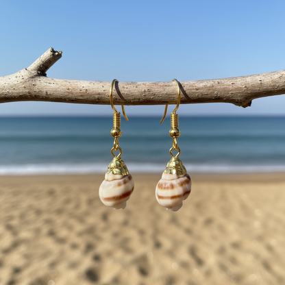 Schelpen oorbellen met kleine schelp en goud edelstaal hangend aan takje met achtergrond zee | Little Ribbed Shell Gold