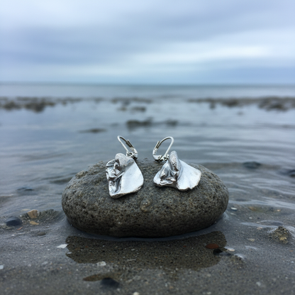 Zilver gekleurde schelpen oorbellen liggend op steen | Shell Silver