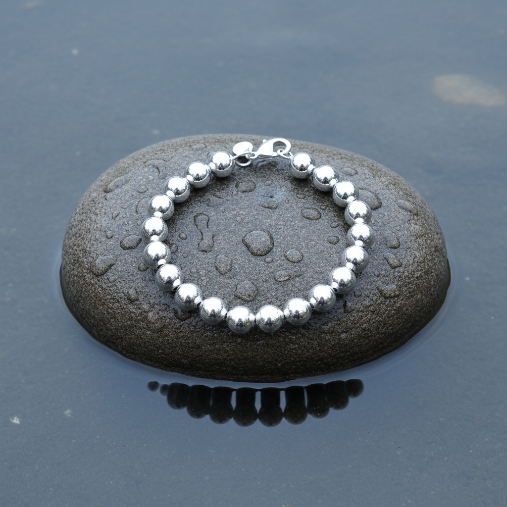 Verzilverde armband met bollen liggend op steen | Molly