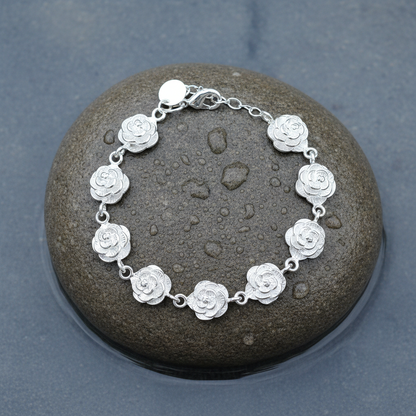 Verzilverd armband met zilveren bloemetjes liggend op steen | Silver Flower