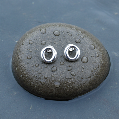 Verzilverde oorknoppen in vorm van O liggend op steen | Silver O