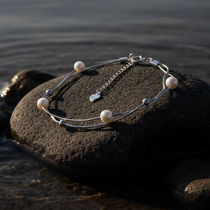 Wit zoetwater parel armband met sterling zilver (925) liggend op steen in water met avondzonlicht | Liv