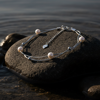 Wit zoetwater parel armband met sterling zilver (925) liggend op steen in water met avondzonlicht | Liv