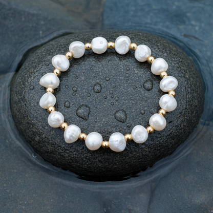 Wit zoetwater parel armband met goud edelstaal liggend op steen in water bovenaanzicht | Esra