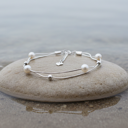 Wit zoetwater parel armband met sterling zilver (925) liggend op steen in water | Liv