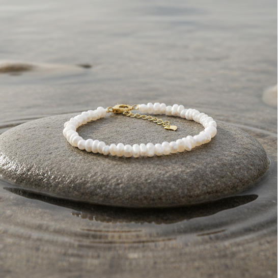 Zoetwater parel armband met kleine witte parels liggend op beige steen in water | set Mily