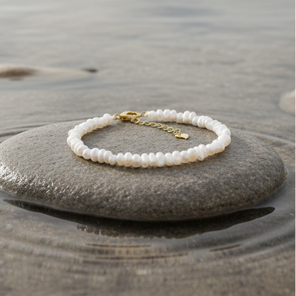 Zoetwater parel armband met kleine witte parels liggend op beige steen in water | set Mily