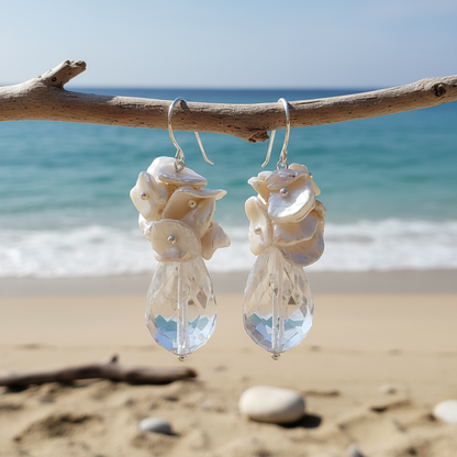 Grote witte zoetwater parel oorbellen met facet geslepen kristal en sterling zilver (925) hangend aan takje met zee achtergrond | Kiomi