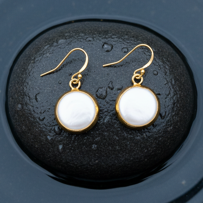 Witte zoetwater parel oorbellen met goud edelstaal liggend op steen in water | One Gold Coin Pearl