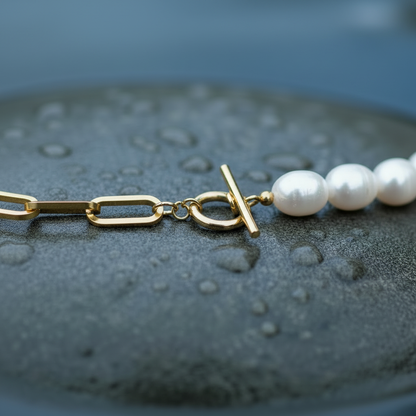 Witte zoetwater parelketting met witte parels en goud edelstaal liggend op steen close up | Baudine