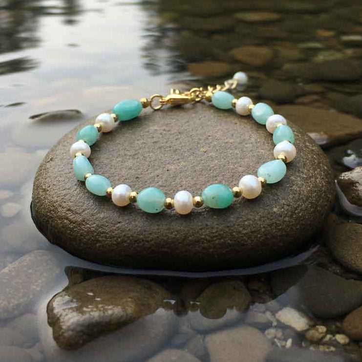 Wit zoetwater parel armband met groene edelsteen amazoniet en goud edelstaal liggend op steen in water| Amazonite Pearl Gold