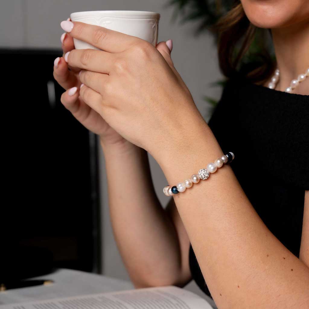 Zoetwater parel armband met witte zalm en blauwe parels en stras steentjes, elastisch, op model met detail | Ariane