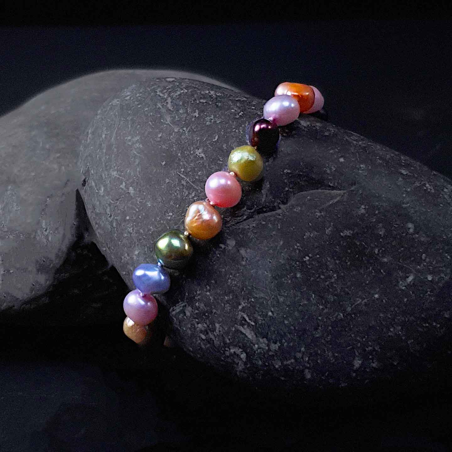 Zoetwater parel armband met veel kleurtjes liggend op steen | set Decorative Bold