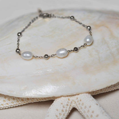 Wit zoetwater parel armband met zilver edelstaal liggend op schelp | Parel armband Eline Zilver