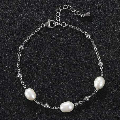 Wit zoetwater parel armband met zilver edelstaal liggend op zwart zand | Parel armband Eline Zilver