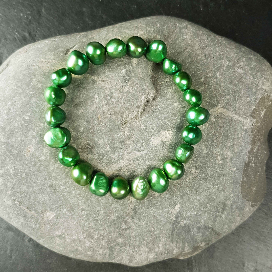 Groen zoetwaterparel armband liggend op steen | Green Pearl