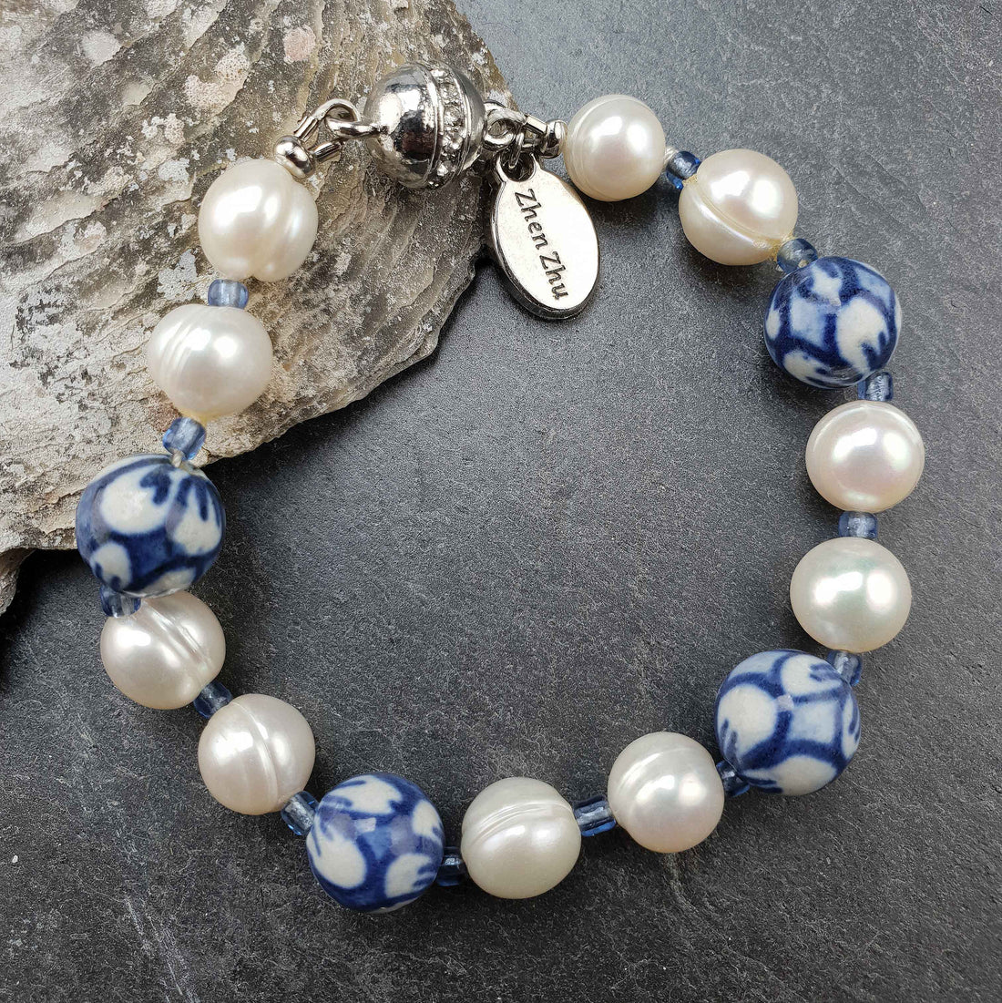 Wit zoetwater parel armband met Delfts blauwe kralen en magneetsluiting liggend op leisteen | Hollands Glorie Flower White