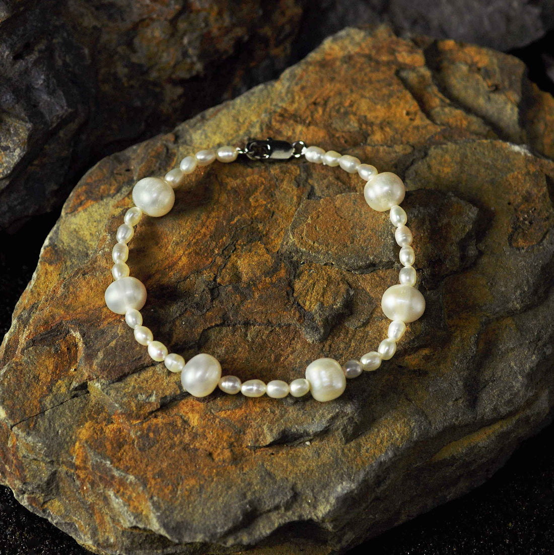 Wit zoetwater parel armband met sterling zilver liggend op steen | Little Bold Pearl