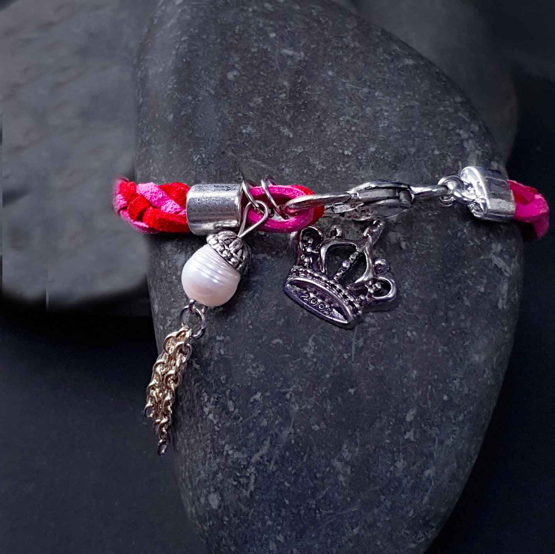 Wit zoetwater parel armband met rood en roze suède liggend op steen | Pearl Charm Suede