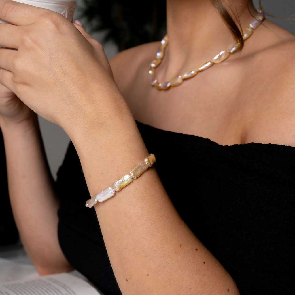Zoetwater parel armband met zalm kleurige rechthoekige parels en sterling zilver (925) op model die thee drinkt | Pearl Rectangle Peach