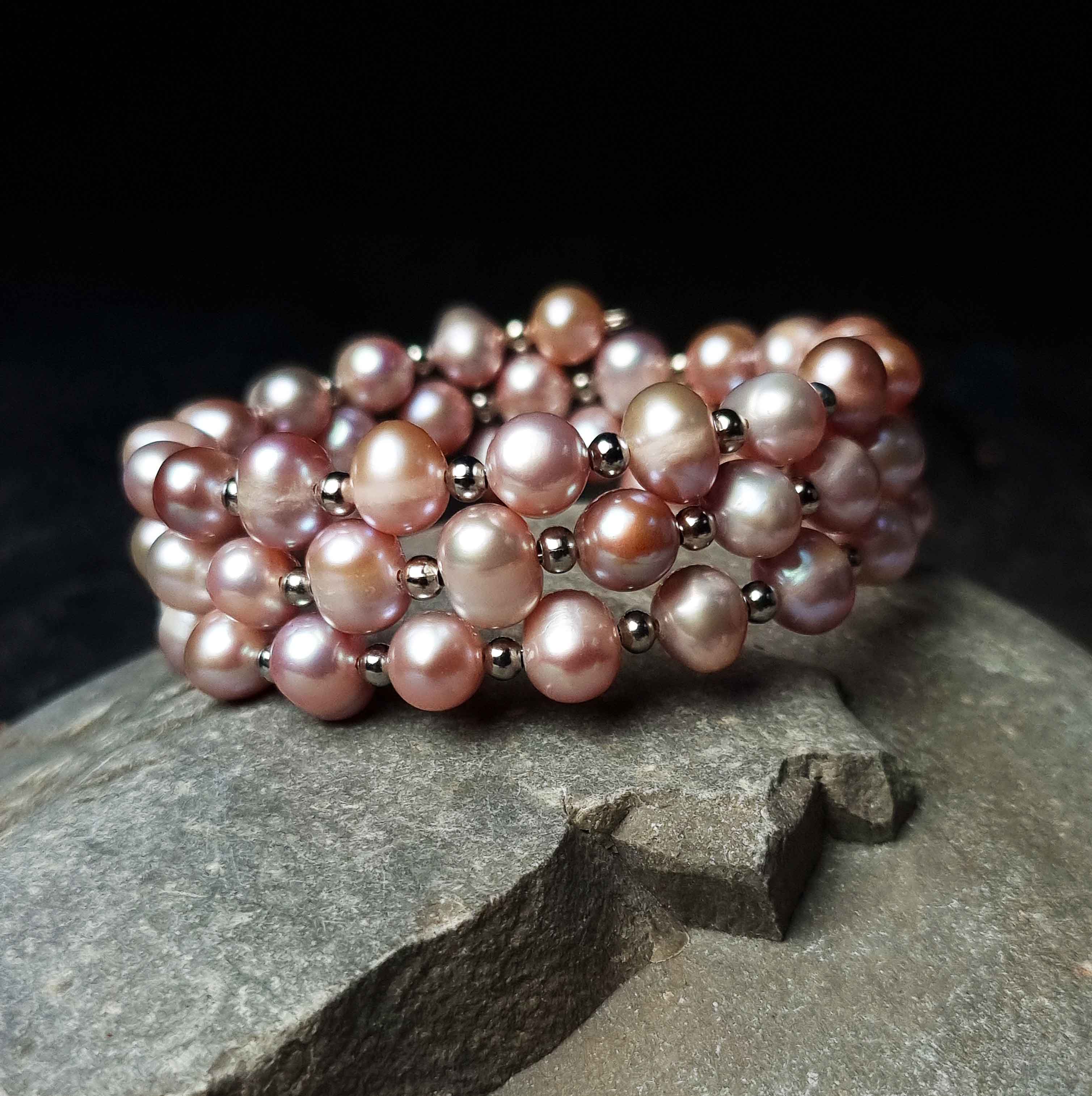 Roze zoetwater parel wikkelarmband liggend op kei| Pink Pearl Wrap