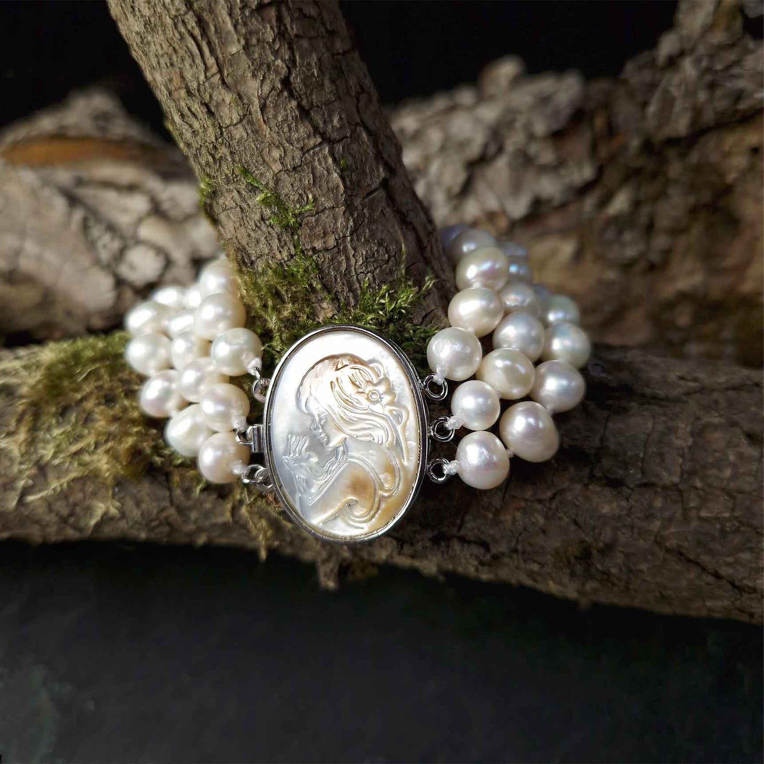 Wit handgeknoopt zoetwater parel armband in 3 rijen met parelmoer liggend om tak| Victoria