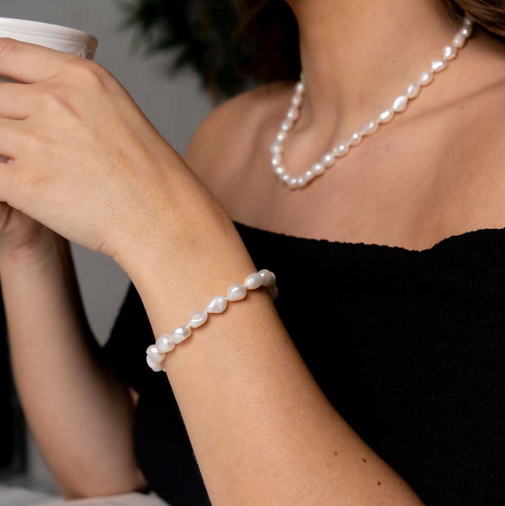 Wit zoetwater parel armband, handgeknoopt op model en drinkt thee | Wola