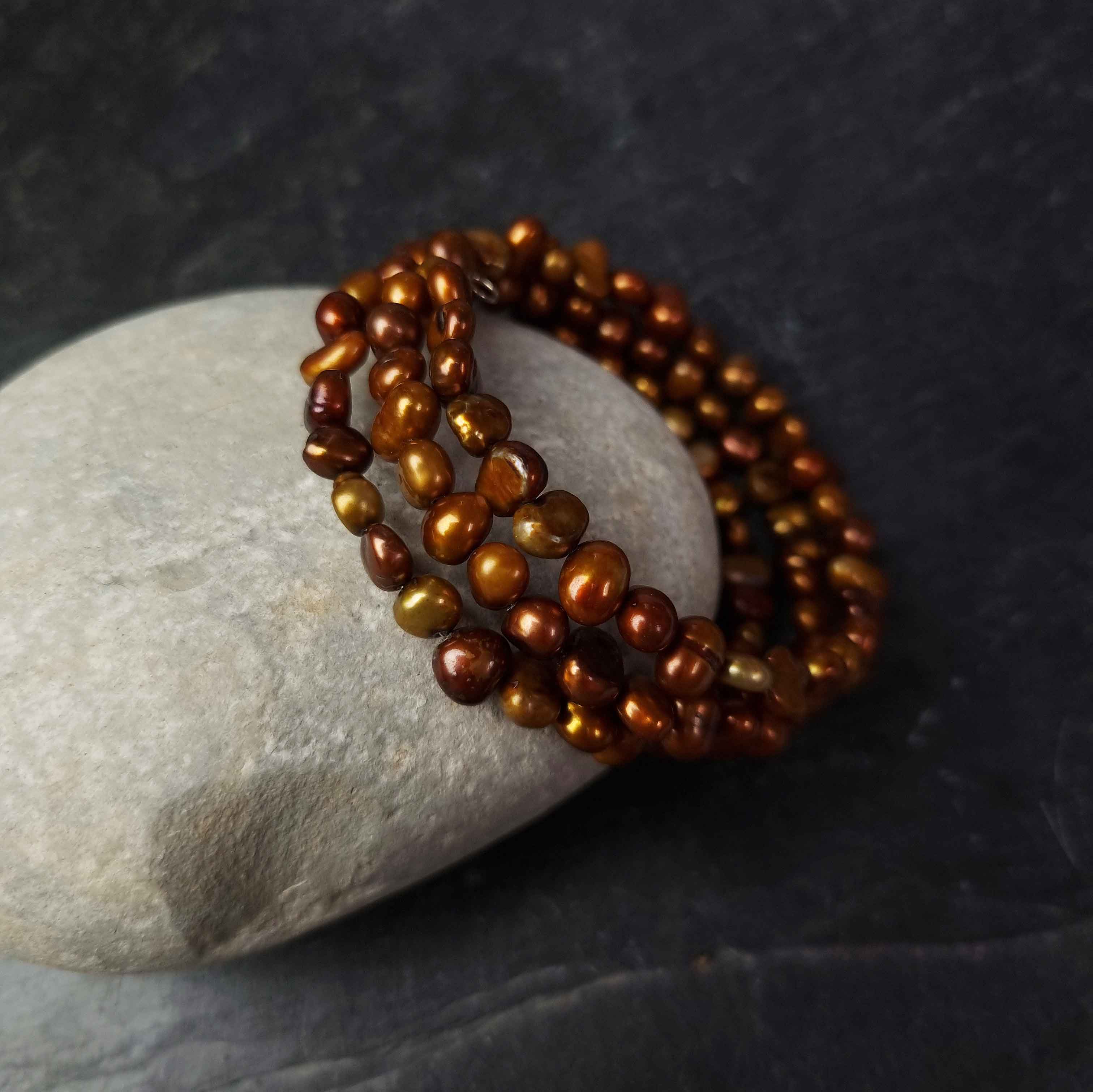 Zoetwater parel wikkel armband met bruin parels liggend tegen kei | Zen Brown