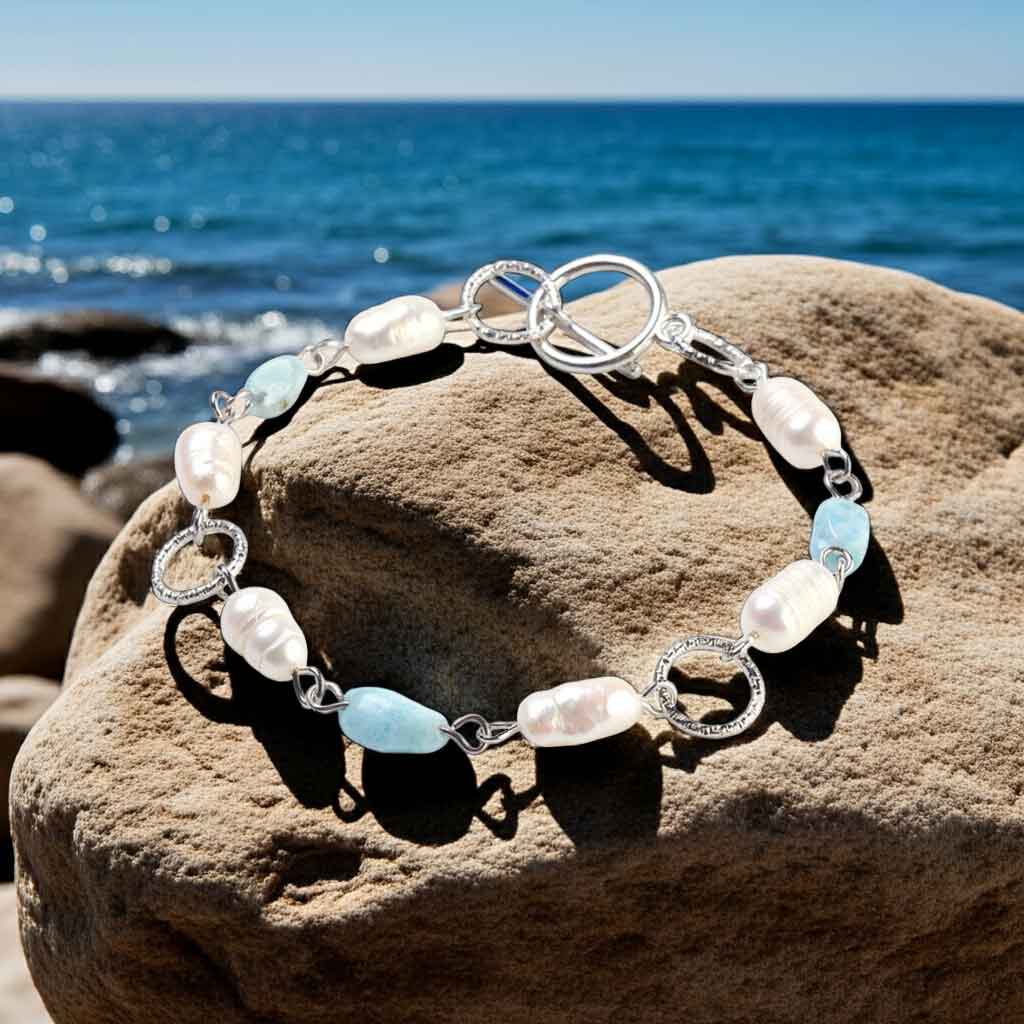 Wit zoetwater parel armband met larimar en edelstaal liggend op rots| Lalita Larimar