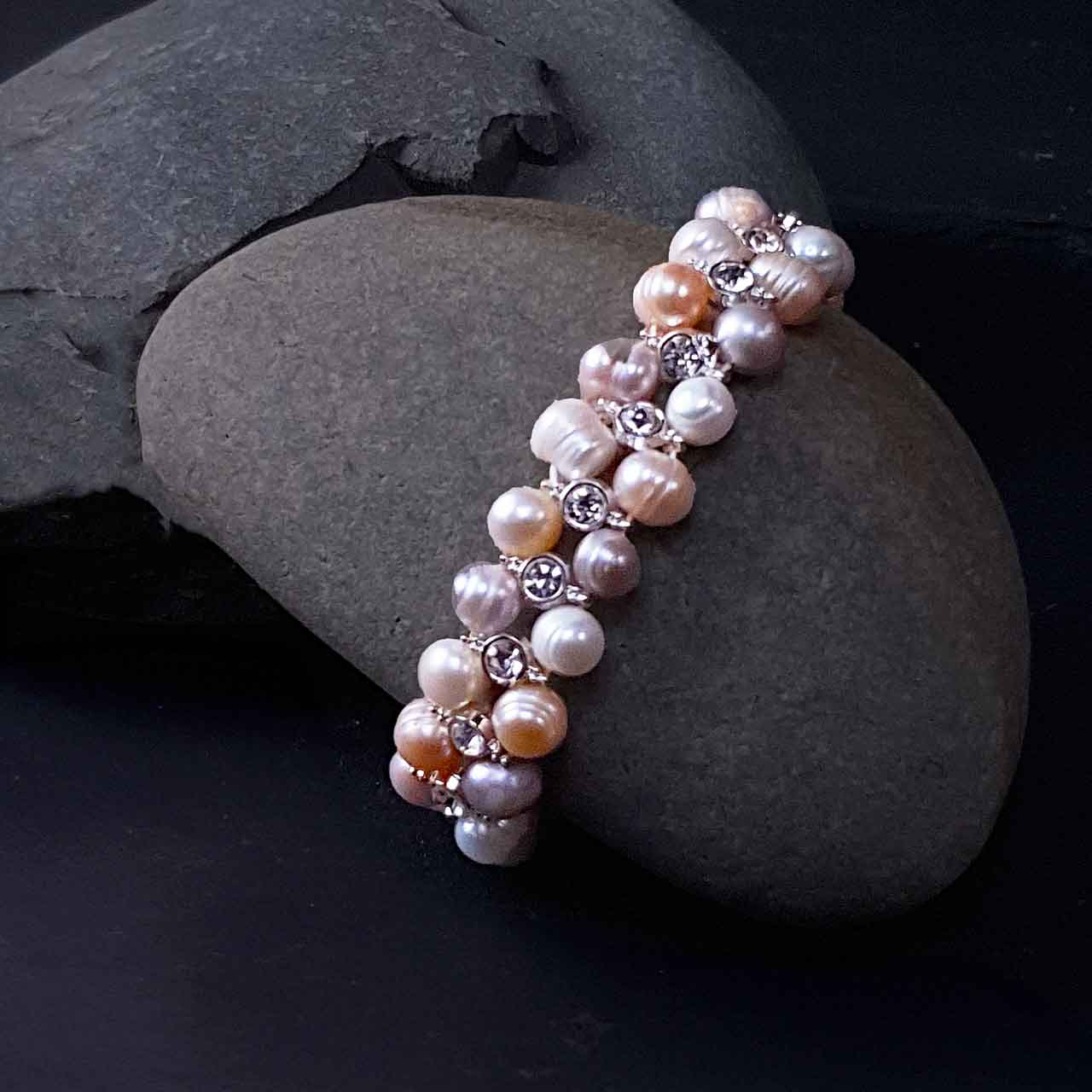 Elastisch zoetwater parel armband met stras steentjes liggend op steen | Double Soft Colors Pearl Bling