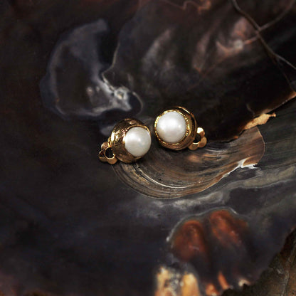 Witte zoetwater parel clips oorbellen met gouden rand liggend in schelp | One Gold Clip Pearl