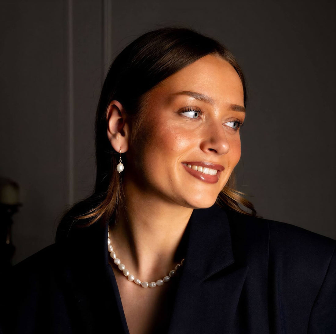 Witte zoetwater parel oorbellen met goud edelstaal op model | Abby