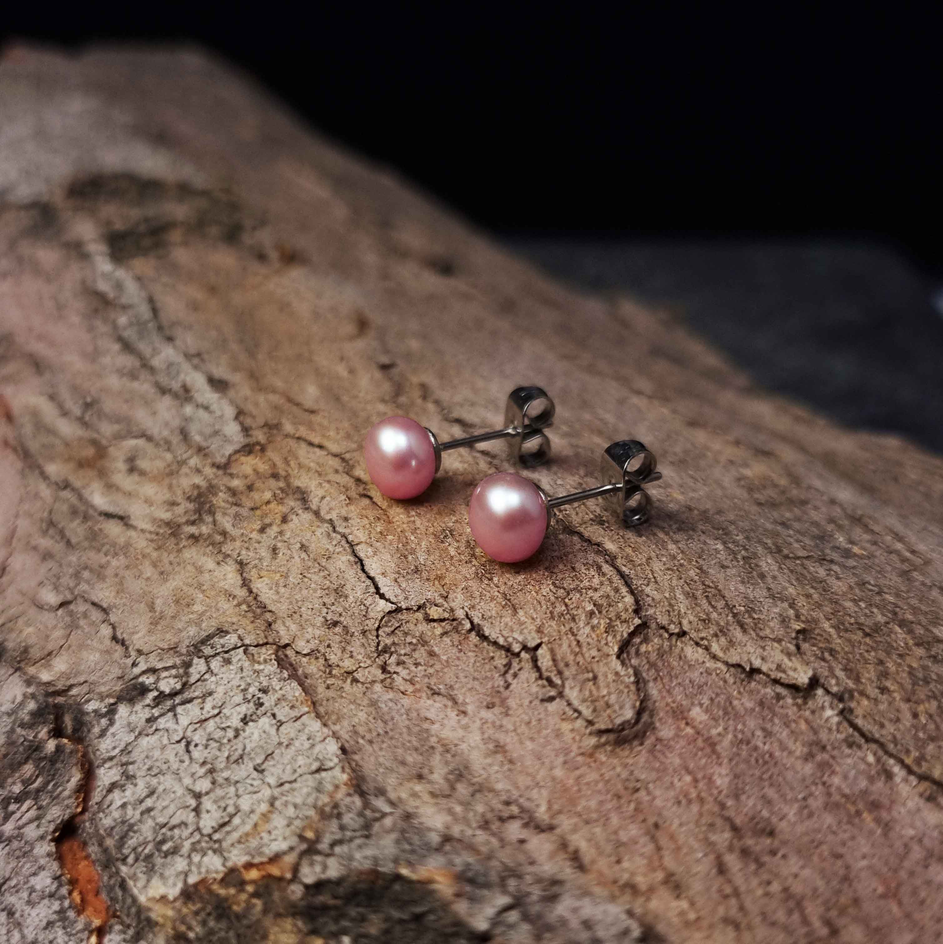 Zoetwater parel oorknopjes met roze parels en edelstaal liggend op hout | Brit P