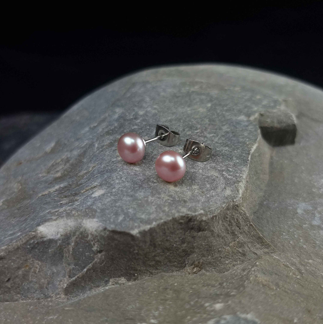 Zoetwater parel oorknopjes met roze parels en edelstaal liggend op steen | Brit P