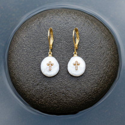 Witte zoetwater parel oorbellen met goud edelstaal en parel hanger is voorzien van stras steentjes in een kruis liggend op steen | Coin Pearl Golden Cross