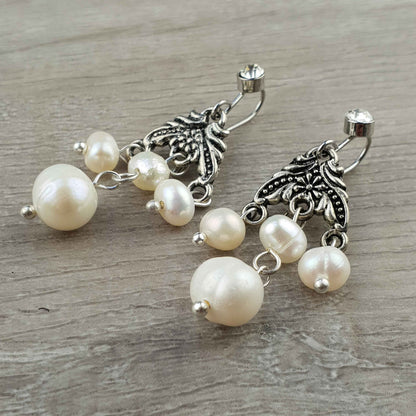 Witte zoetwater parel oorbellen met stras steentje liggend op hout | Emmy