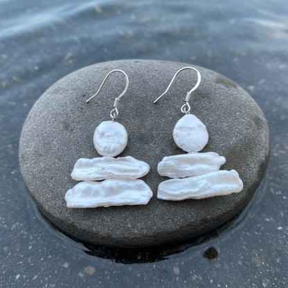 Zoetwater parel oorbellen met witte parels en sterling zilver (925) liggend op natte steen | Wendy