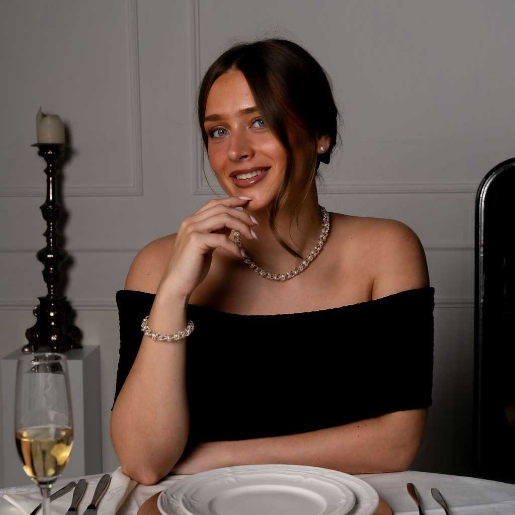 Witte zoetwater parel set bestaande uit een parelketting en parel armband met beige glaskristallen met model aan tafel | set Pearl Crystal Clear