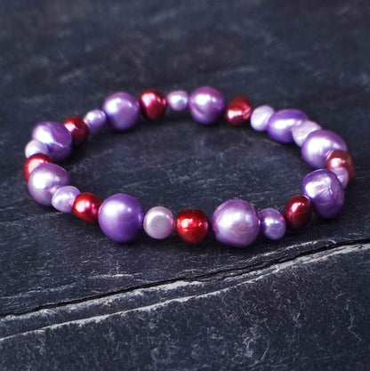 Zoetwater parel armband met lila en rode parels liggend op leisteen | Pulla